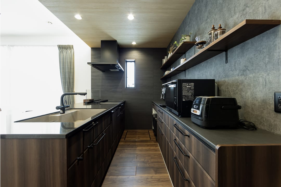 LDKのアクセントにもなる重厚感のあるキッチン。背面収納も同色で洗練された印象に