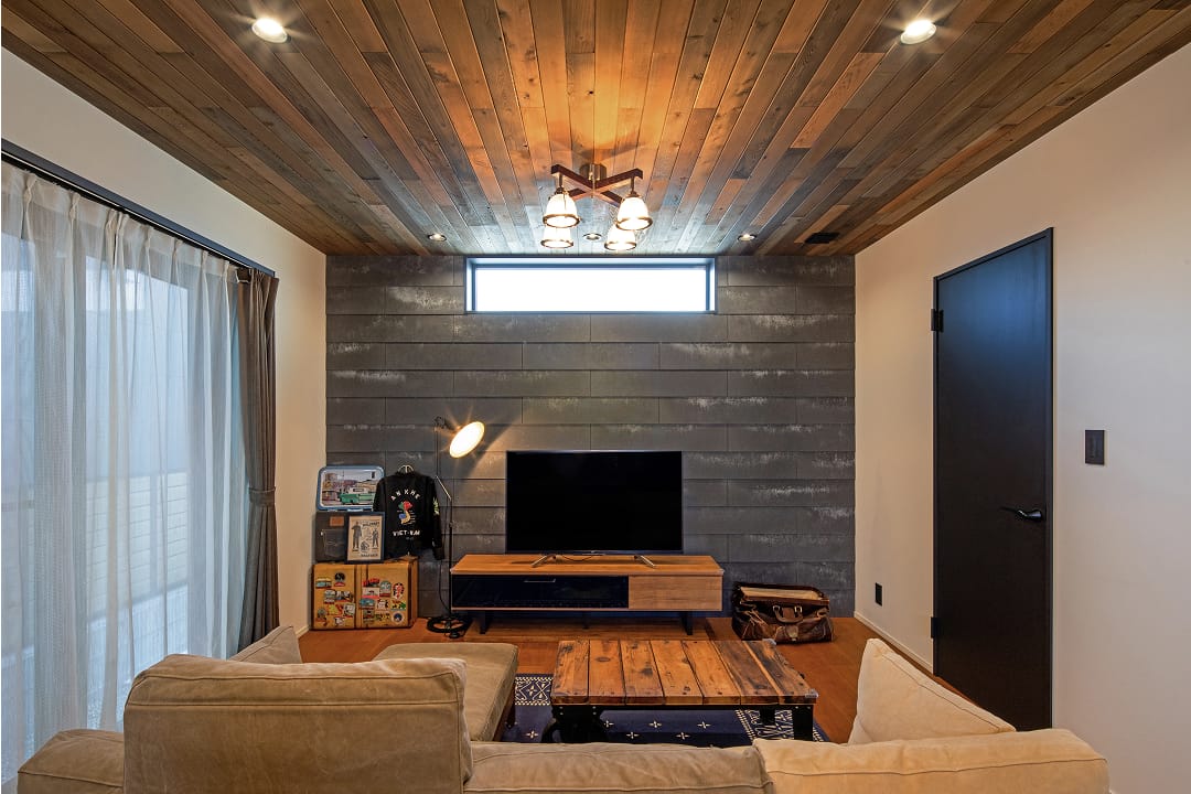 レッドシダーの天井と石目調の壁材『ソリド』が上質な空間を演出するリビング