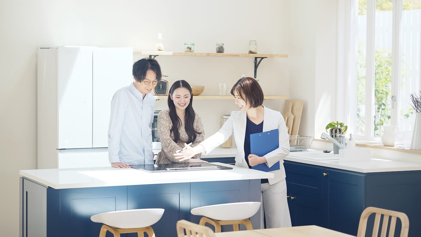 展示場を訪れた夫婦を案内する営業担当